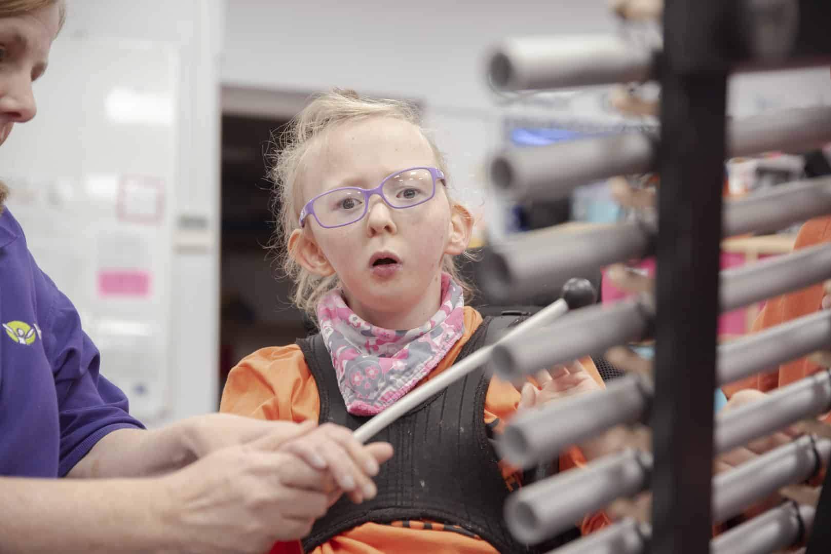 During a music therapy session at one of our partner organisations, a young client is focused as they play the xylophone.