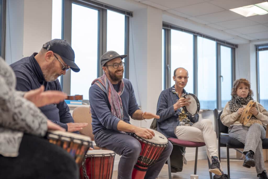 At partner organisation ReCoCo, music therapy takes place as people make music with drums and tambourines.