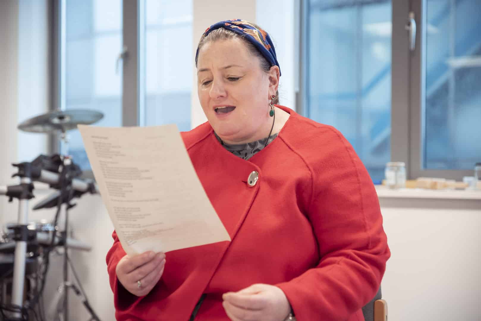 A person sings passionately from a lyric sheet during a music therapy session at ReCoCo, one of our partner organisations.
