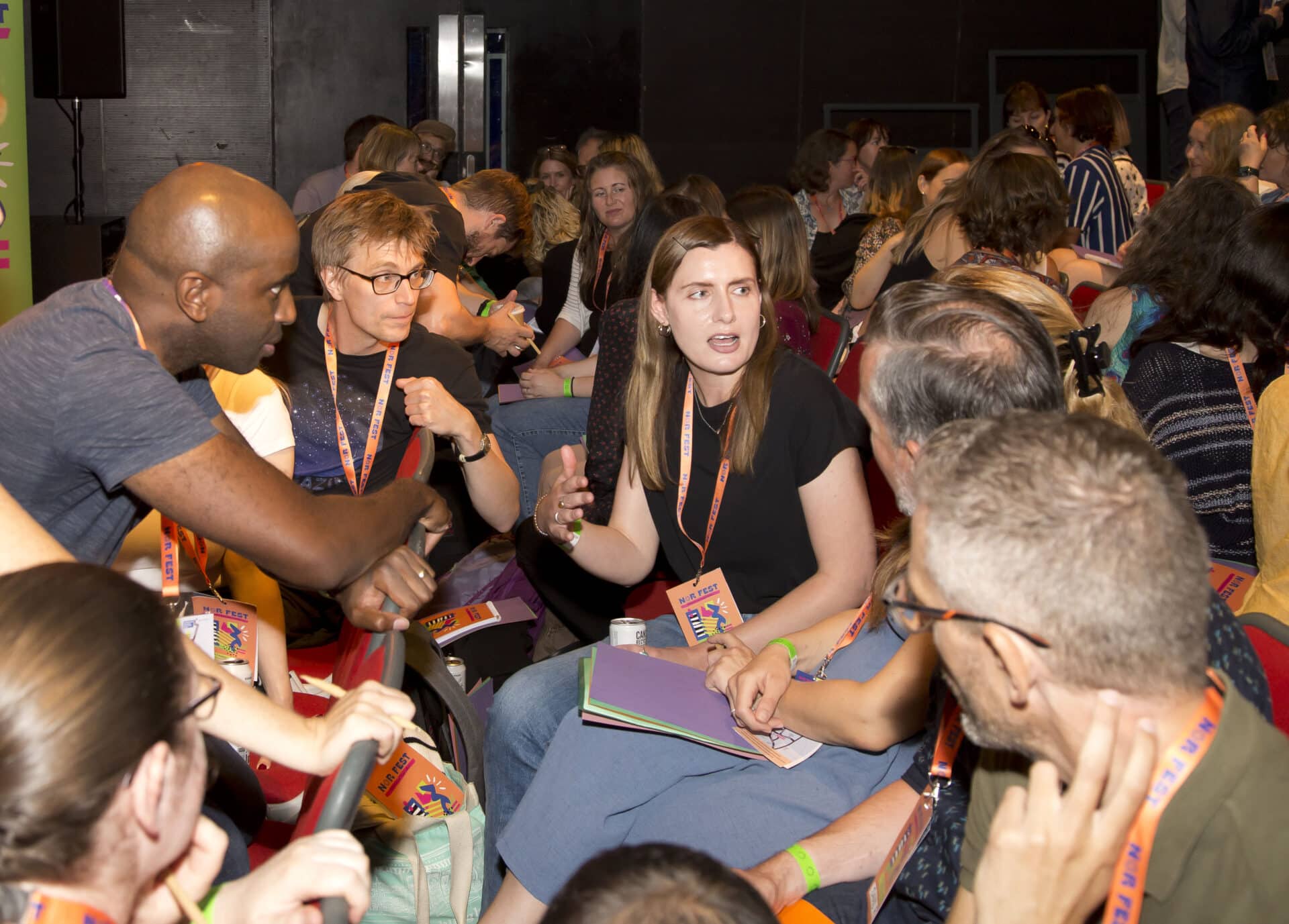 Nordoff and Robbins team members talk to each other in a group at the Nor Fest colleague get together event.