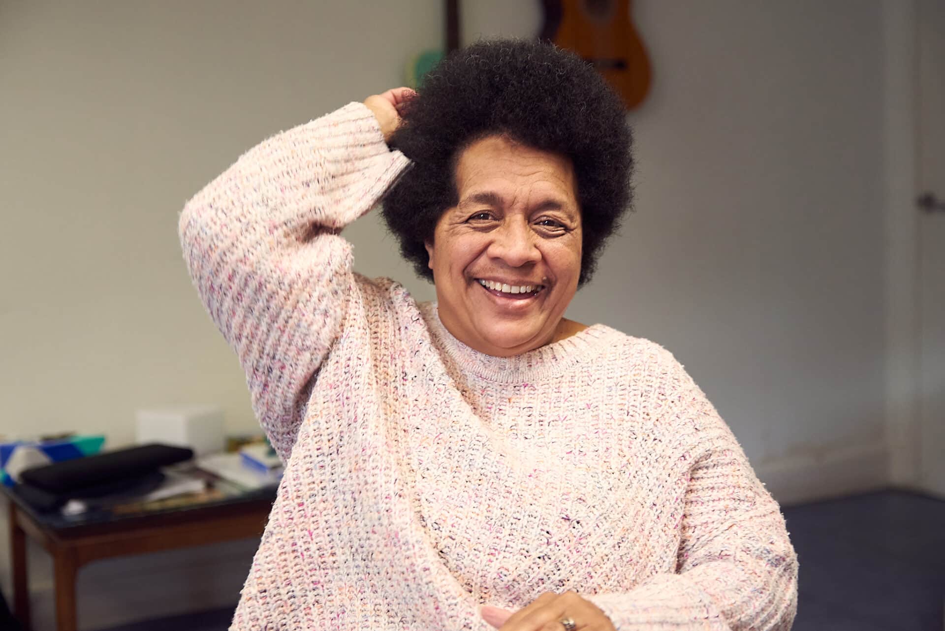 A cheerful client is smiling and laughing, as they take part in music therapy at one of our partner organisations.