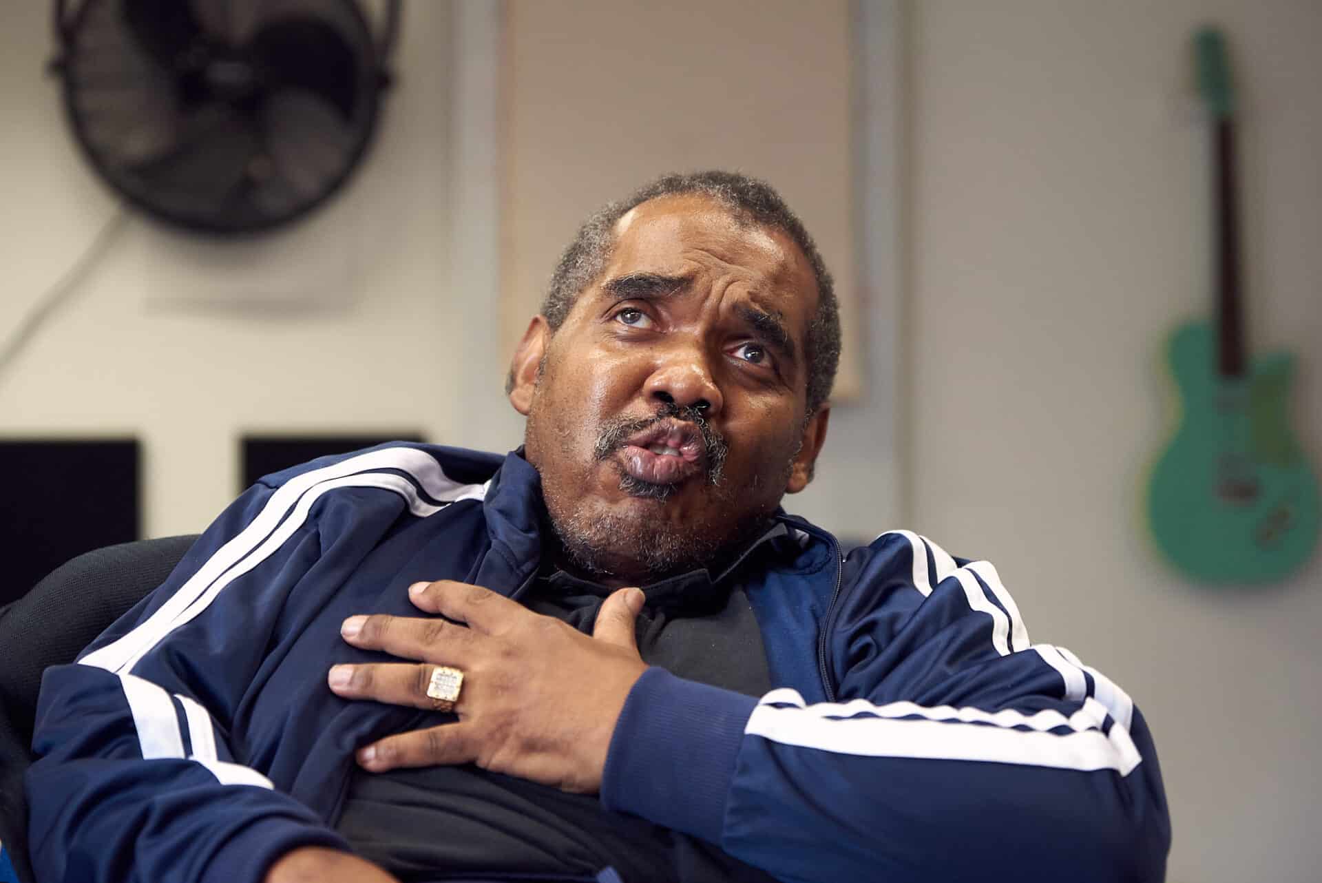 With one hand on their chest, a person passionately sings during music therapy at Headway, a Nordoff and Robbins partner organisation.