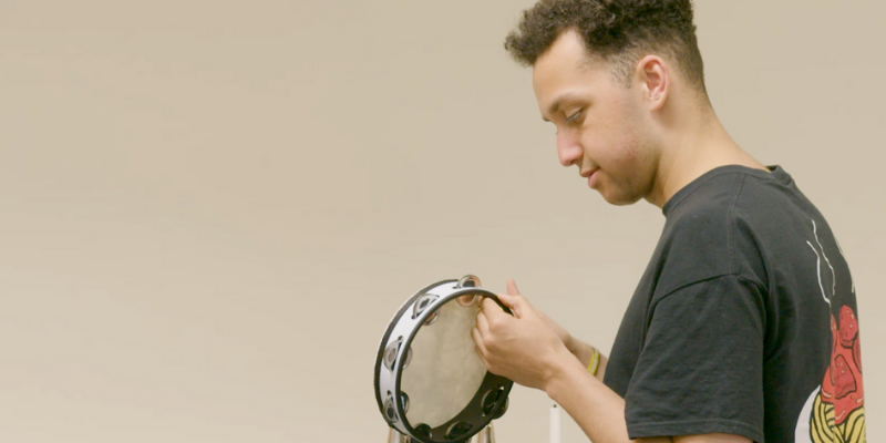 Harvey holds a tambourine during a music therapy session