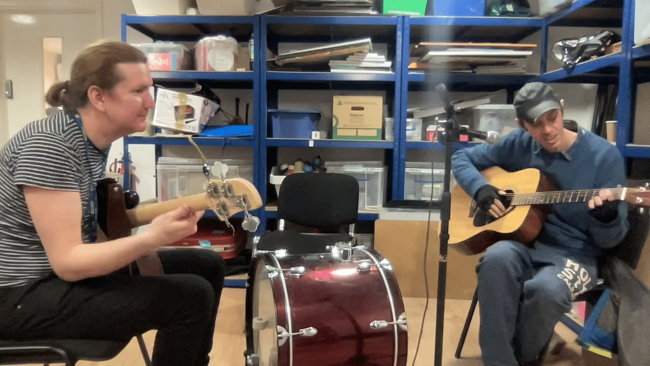 Scott plays the guitar with music therapist Andy, during a music therapy session.