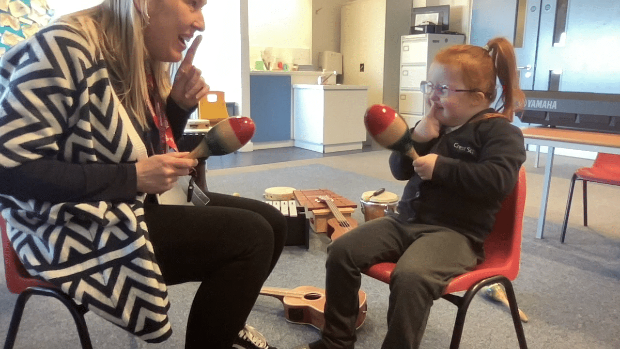 Emmie takes part in the 'shake and stop' song with music therapist Nicky, during a session.