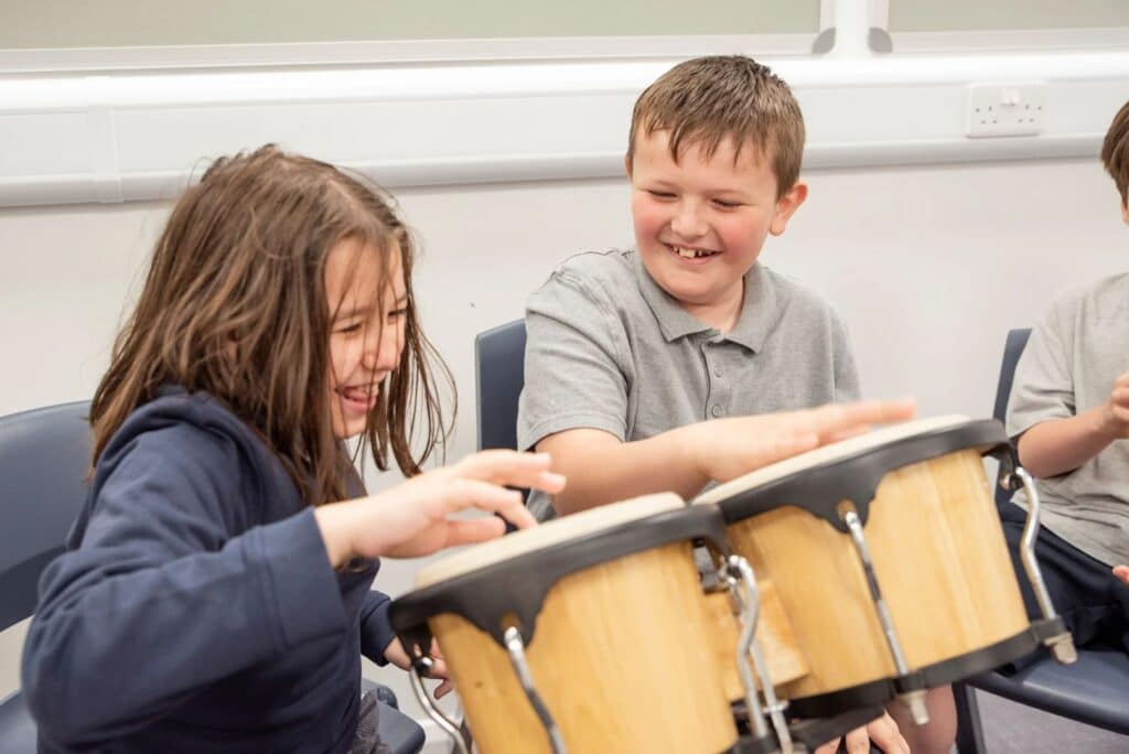 Pupils in the Riverbrae School Choir play the drums together.