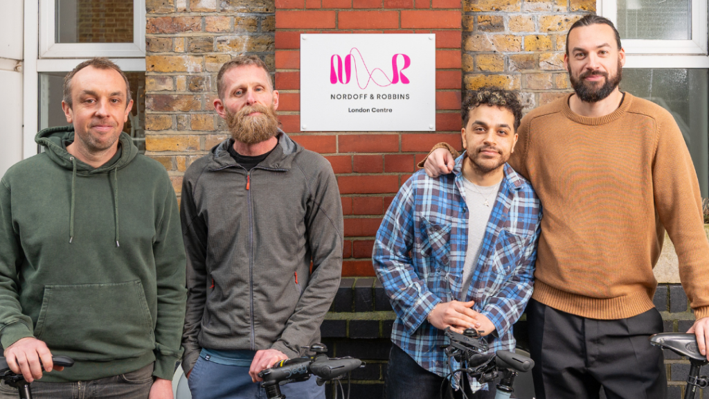 Darren, Matt, Brian MacDonald (PVRIS), Ross MacDonald (The 1975) stand with their bikes outside the Nordoff and Robbins London Centre
